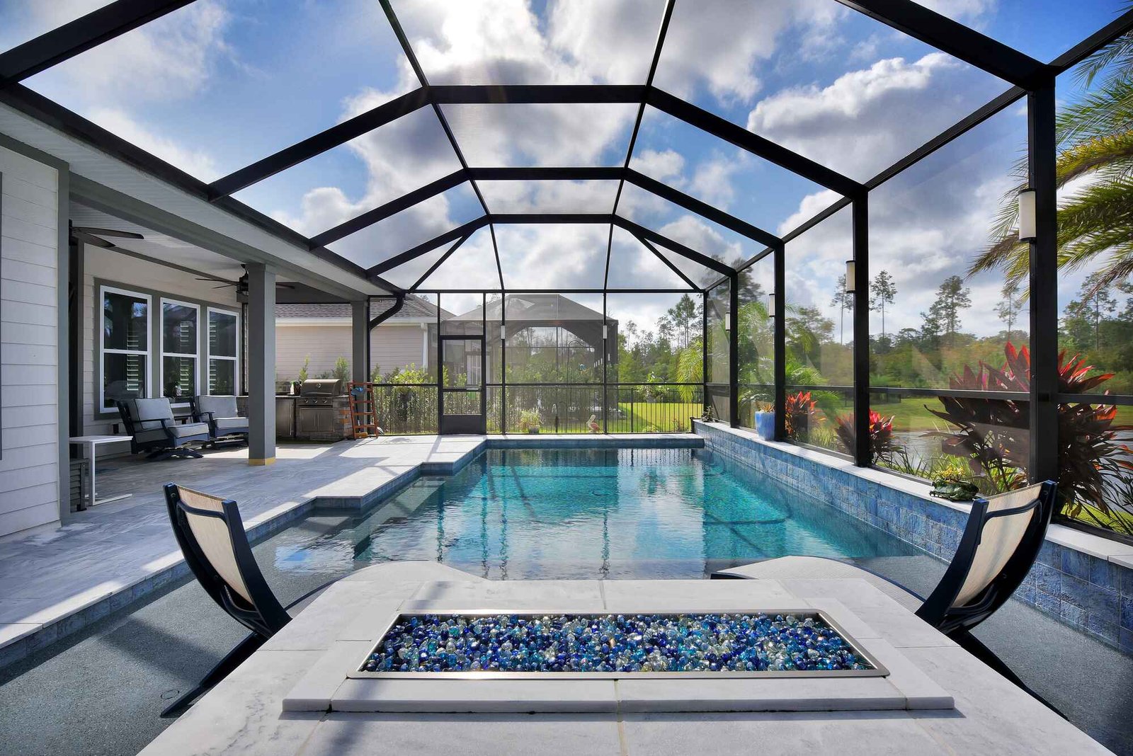 Large pool screen enclosure installation in St. Augustine, FL with modern backyard pool